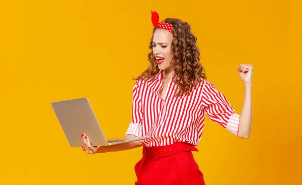 Mulher alegre engraçado com laptop no fundo amarelo — Fotografia de Stock