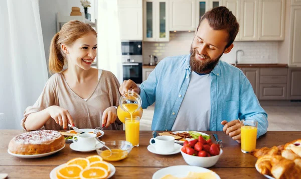 Familia feliz pareja desayunar en la cocina por la mañana — Foto de Stock