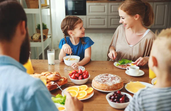 Família mãe pai e filhos têm café da manhã na cozinha em m — Fotografia de Stock