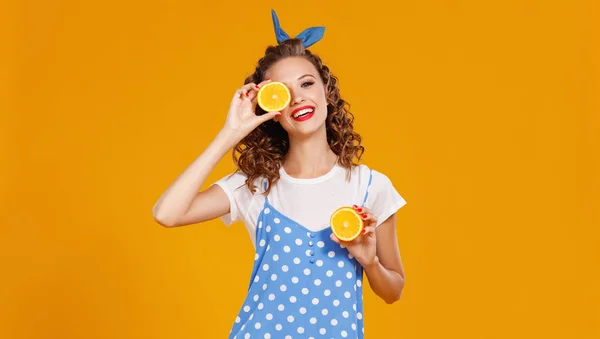 Joyeuse jeune femme bouclée fille avec orange sur bac jaune — Photo