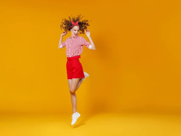 Concept heureux émotionnel jeune femme en rouge saut sur jaune — Photo