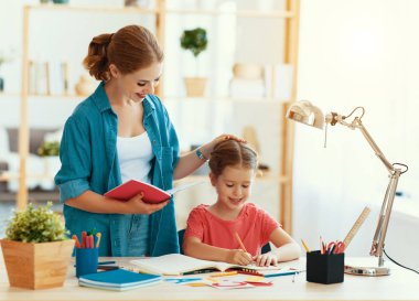 Anne ve çocuk kızı ödev yazma ve okuma yapıyor 