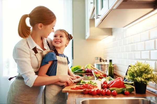 Glückliche Familienmutter mit Kind bereitet Gemüsesalat zu — Stockfoto