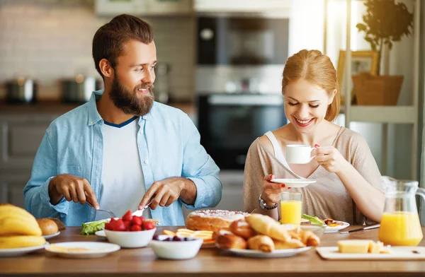 家族の幸せなカップルは朝にキッチンで朝食を持っています — ストック写真