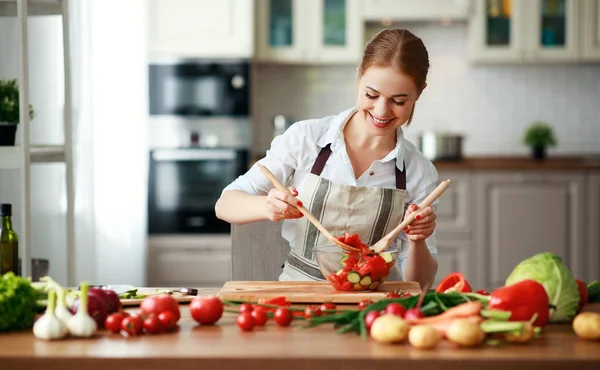 Gelukkige vrouw die groente salade bereidt in keuken — Stockfoto