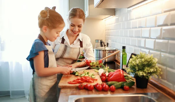 Счастливая мать семьи с ребенком девочка готовит овощной салат — стоковое фото