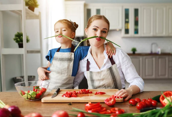 Glückliche Familienmutter mit Kind bereitet Gemüsesalat zu — Stockfoto