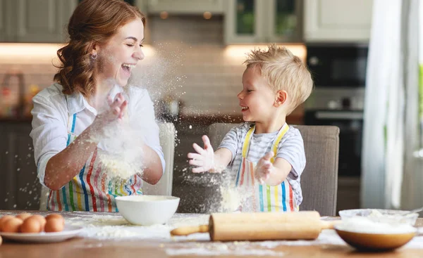 Familia feliz en la cocina. madre y el niño preparando la masa, hornear —  Fotos de Stock