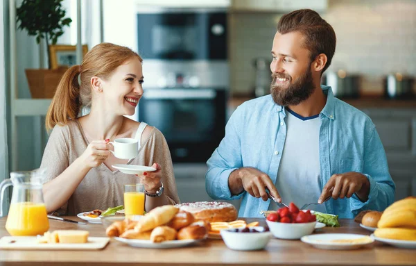 Familia feliz pareja desayunar en la cocina en la mañana — Foto de Stock