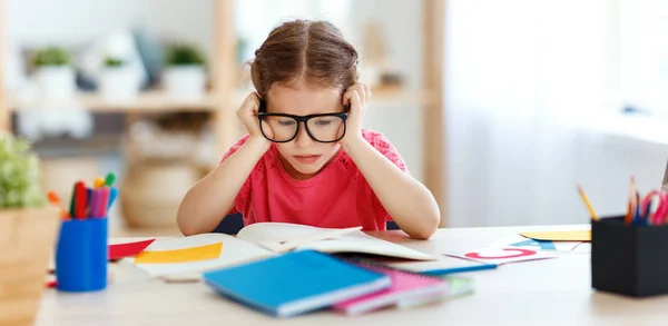 Müdes Kindermädchen bei den Hausaufgaben — Stockfoto