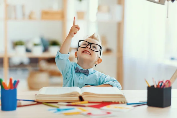 Funny child  boy  doing homework writing and reading at home — Stock Photo, Image