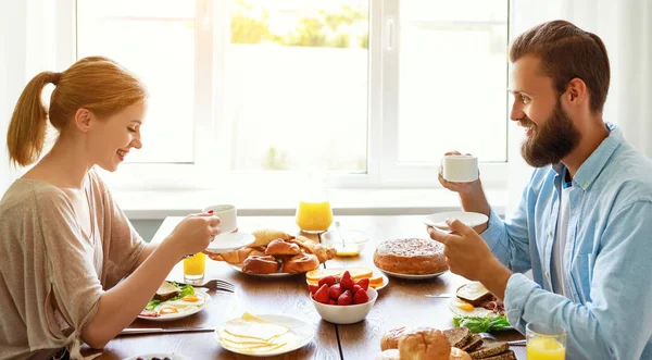 Família casal feliz tem café da manhã na cozinha em mornin — Fotografia de Stock