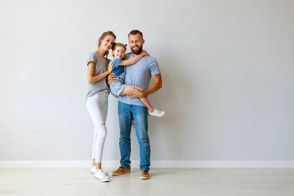 Happy family mother father and child  near an empty wall — Stock Photo, Image