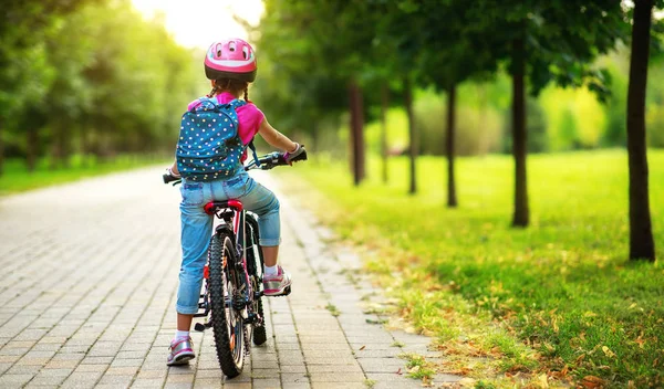 Happy cheerful child girl riding a bike in Park in natur — Stock Photo, Image