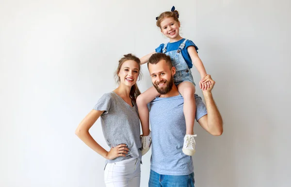 Boş bir duvarın yanında mutlu aile anne baba ve çocuk — Stok fotoğraf