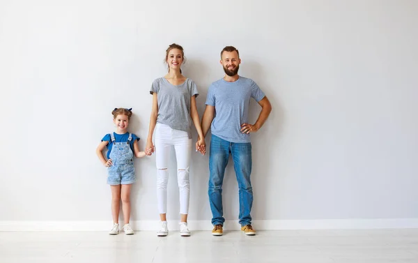 Boş bir duvarın yanında mutlu aile anne baba ve çocuk — Stok fotoğraf