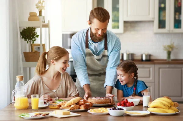 Семья мать отец и ребенок дочь имеют завтрак на кухне — стоковое фото