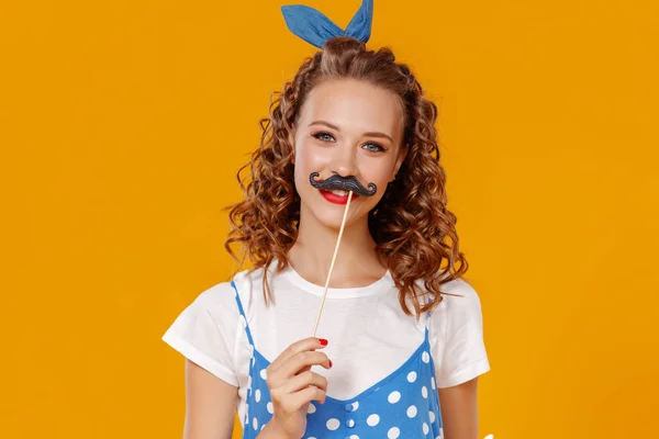 Jovem linda garota engraçada com bigode na parte traseira amarela colorida — Fotografia de Stock