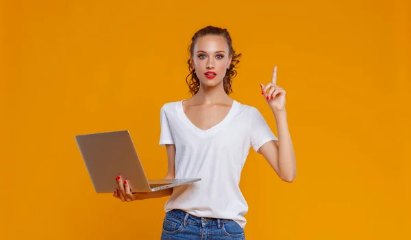 Divertida mujer alegre con portátil en el fondo amarillo — Foto de Stock