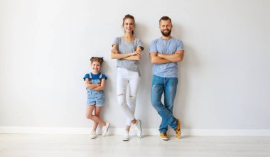 boş bir duvarın yanında mutlu aile anne baba ve çocuk