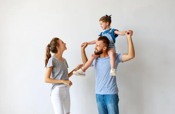 Família feliz mãe pai e filho perto de uma parede vazia — Fotografia de Stock