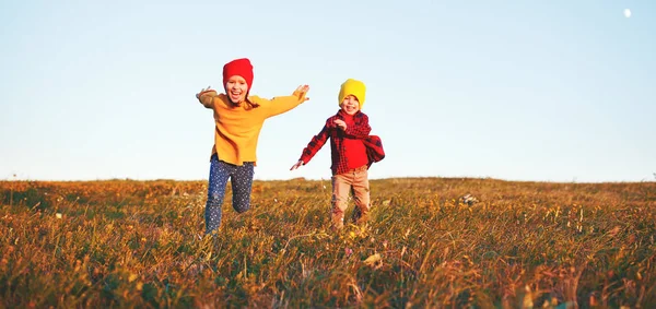 Happy kids   boy and girl running and laughing on autumn nature — Stock Photo, Image