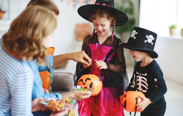 Wakacje Halloween. dzieci poprosić rodziców o słodycze w kosztach — Zdjęcie stockowe