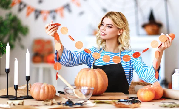 Happy girl is cutting  pumpkin and is preparing for holiday Hall — Stock Photo, Image