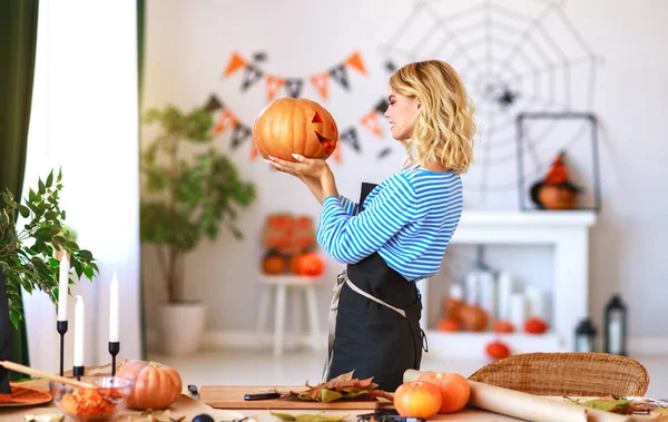 Happy girl is cutting  pumpkin and is preparing for holiday Hall — Stock Photo, Image