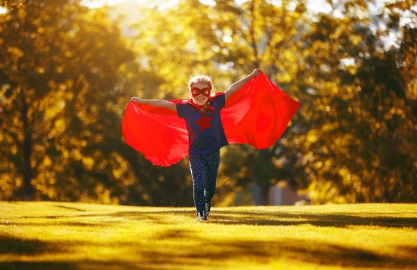 Conceito criança feliz herói super-herói em manto vermelho na natur — Fotografia de Stock