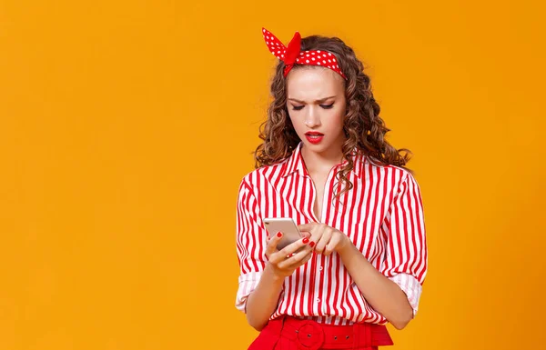 Funny cheerful woman with phone on yellow backgroun — Stock Photo, Image