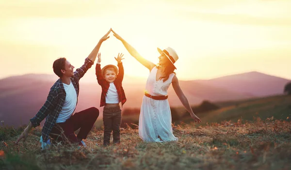 Pai de família feliz de mãe e filho de criança na natureza no pôr do sol — Fotografia de Stock