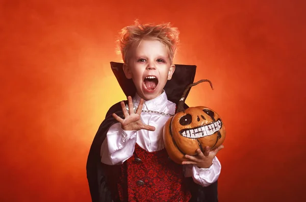 Heureux enfant garçon en costumes de vampire dans fond rouge foncé i — Photo