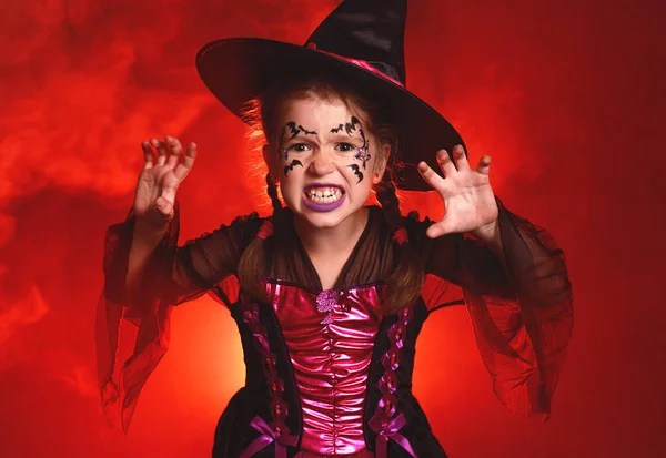 Felice bambina in costume di strega in sfondo rosso scuro in — Foto Stock