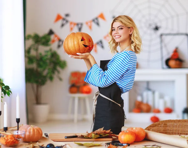 Happy girl is cutting  pumpkin and is preparing for holiday Hall — Stock Photo, Image