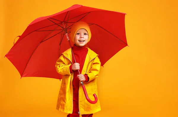 Jonge gelukkige emotionele vrolijke jongen lachen met rode paraplu — Stockfoto