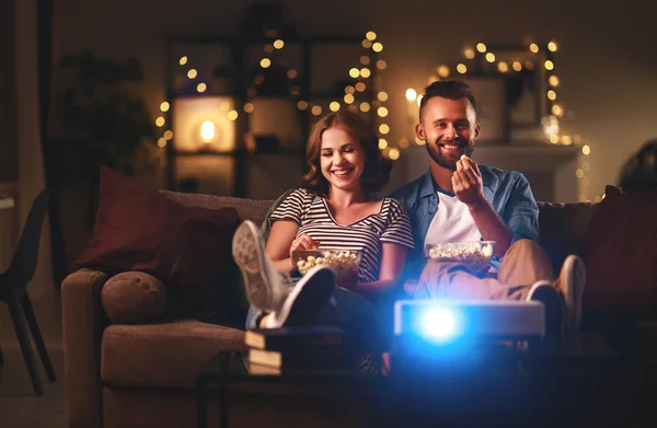 Семейная пара смотрит телевизор дома на диване — стоковое фото