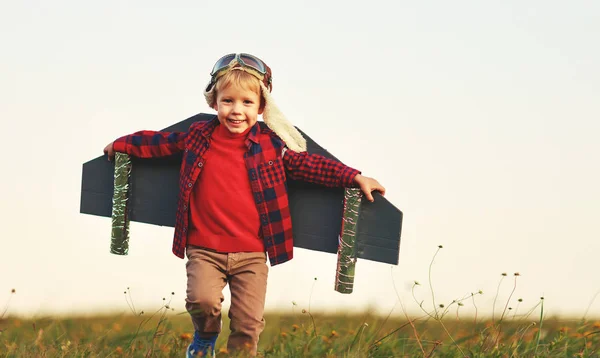 Child pilot aviator with wings of airplane dreams of traveling i — Stock Photo, Image