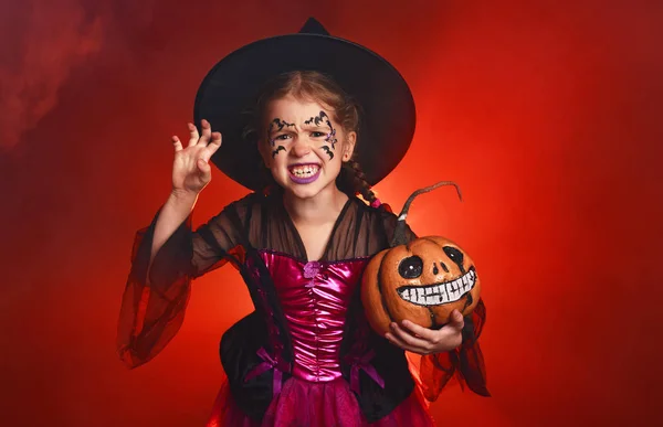 에 어두운 빨간 배경에 마녀의 의상에 행복 한 아이 소녀 — 스톡 사진