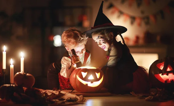 Bambini felici in costumi di strega e vampiro in una casa buia — Foto Stock