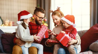 Mutlu aile Noel sabahı hediyelerini açar.