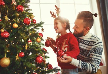 Mutlu aile babası ve kız çocuğu Noel ağacını süsledi