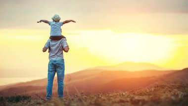 Mutlu aile babası ve oğlu güneş doğarken