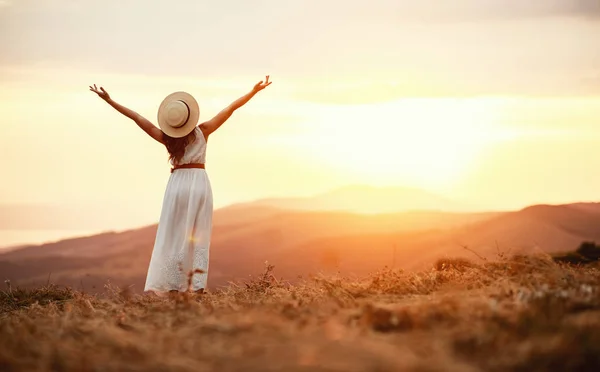 Femme heureuse debout avec le dos sur le coucher du soleil dans la nature — Photo