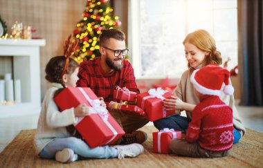 Mutlu aile Noel sabahı hediyelerini açar.