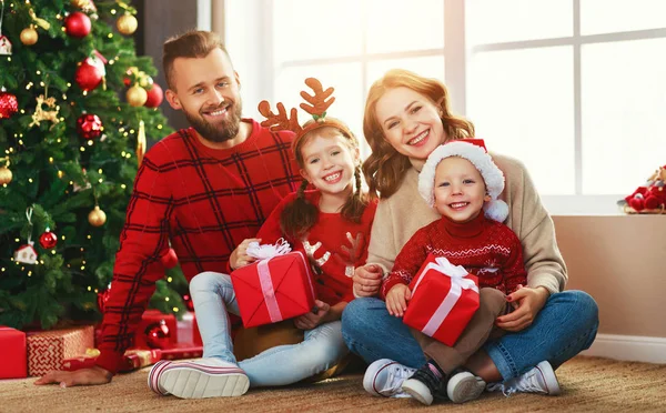 Gelukkig gezin met geschenken in de buurt van kerstboom bij hom — Stockfoto