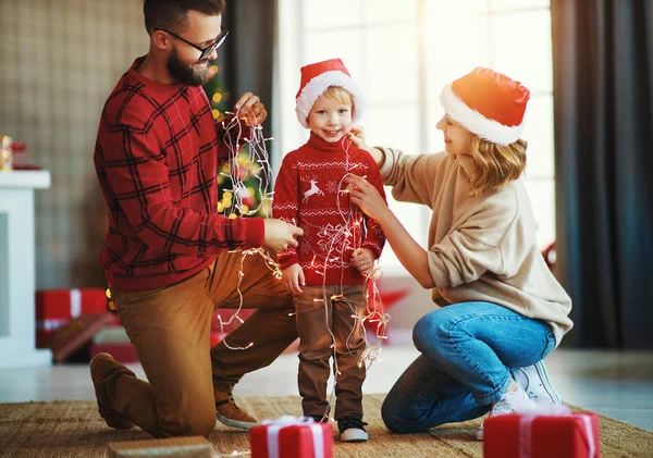 Mutlu aile Noel ağacını süslüyor, aileler çocukla oynuyor. — Stok fotoğraf