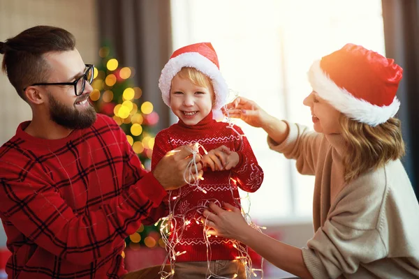 Ευτυχισμένη οικογένεια διακοσμούν χριστουγεννιάτικο δέντρο, οι γονείς παίζουν με το παιδί έτσι — Φωτογραφία Αρχείου