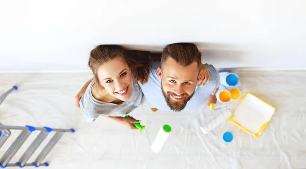 Jovem casal feliz está reparando e pintura parede em casa — Fotografia de Stock