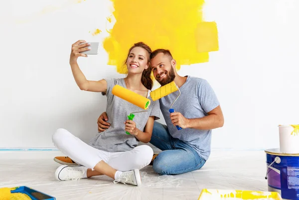 Giovane coppia felice sta riparando e pittura muro a hom — Foto Stock